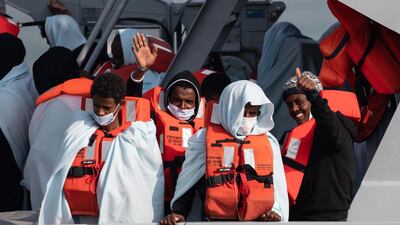 The possibility of transferring asylum seekers to the remote islands was eventually shelved. Migrants wave and give a thumbs up on board HMC Seeker. Getty Images