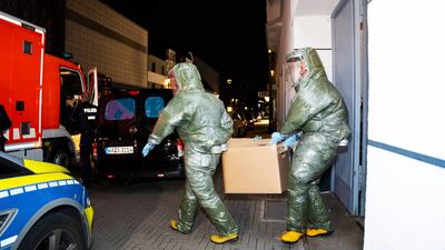 Investigators in protective suits remove items from a house in Castrop-Rauxel, western Germany. AP