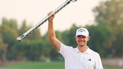 Nicolai Hojgaard of Denmark lifts the DP World Tour Championship trophy on the 18th green on the Earth Course at Jumeirah Golf Estates on November 19, 2023. Getty Images