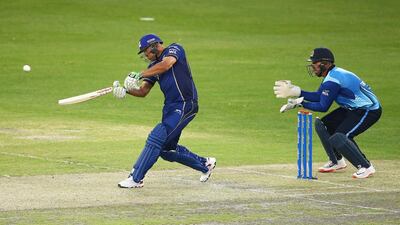 DUBAI, UNITED ARAB EMIRATES - JANUARY 29: Andrew Symonds of Capricorn Commanders hits out watched by wicketkeeper Brendan Taylor of Leo Lions during the Oxigen Masters Champions League 2016 match between Capricorn Commanders and Leo Lions at Dubai International Cricket Stadium on January 29, 2016 in Dubai, United Arab Emirates. (Photo by Francois Nel/Getty Images)