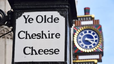 A sign for Ye Olde Cheshire Cheese venue, once popular with journalists, is displayed next to a clock on the facade of the former Daily Telegraph building in Fleet Street. Carl Court / Getty Images