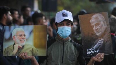 An Iraqi boy carries the portraits of Iraqi commander Abu Mahdi al-Muhandis and Iranian Revolutionary Guards commander Qasem Soleimani during a demonstration in Baghdad's western Shoala neighbourhood. AFP