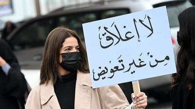 A business owner carries a placard that reads 'No closure without compensation' during a protest in Kuwait City against the closure of salons and health clubs in Kuwait as a measure to stem the spread of the coronavirus. EPA