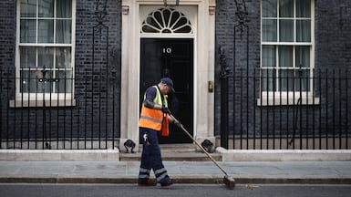 A street cleaner sweeps the gutter outside 10 Downing Street as Britain's Prime Minister Keir Starmer prepares to make a statement on his future. AFP