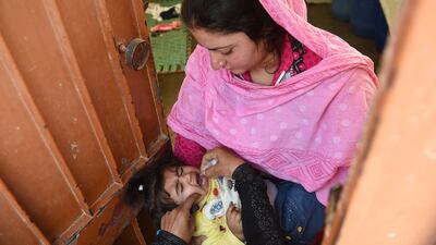 A Pakistani health worker administers polio drops during a door-to-door immunisation campaign in Karachi. Asif Hassan / AFP