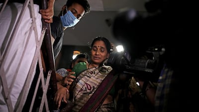 Asha Devi is crowded by journalists as she leaves her home after four men convicted of raping her daughter were hanged. AP Photo