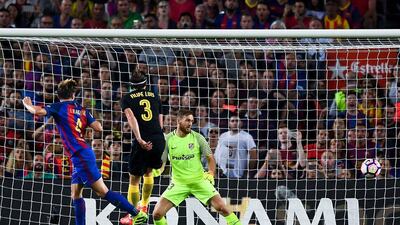 Ivan Rakitic of FC Barcelona scores the opening goal past Filipe Luis and the goalkeeper Jan Oblak of Atletico Madrid. David Ramos / Getty Images