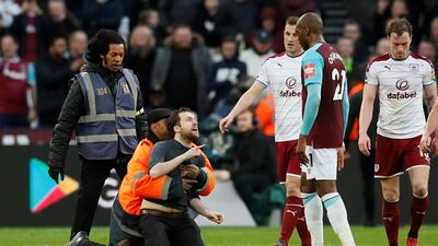 A fan is tackled by stewards after invading the pitch. David Klein / Reuters