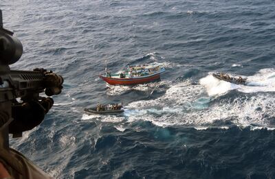 The dhow crew holding their hands up in surrender as the Royal Marines close in. PA
