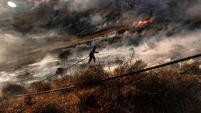 A firefighter douses flames near Kotsiatis, on the outskirts of the Cypriot capital Nicosia. AFP