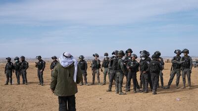 A Bedouin man looks on as Israeli security forces stand guard. AP