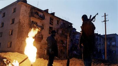 Soldiers stand near a burning crater created by a 500-kilogram bomb dropped by a Russian plane in 1999 onto a residential area of Grozny, Chechnya, the setting for the journalist-turned-freedom fighter Mikail Eldin’s memoir The Sky Wept Fire. Laurent Van Der Stockt / Gamma-Rapho via Getty Images