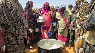 Sudan's civil war has forced many people to live in camps and shelters, such as these women gathering for a hot meal near Al Obeid. AFP