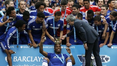 Chelsea's Nemanja Matic, centre top, and manager Jose Mourinho place a crown on Didier Drogba during their Premier League trophy ceremony on Sunday. Adrian Dennis / AFP