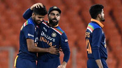 India's Washington Sundar celebrates with captain Virat Kohli after taking the wicket of England batsman Dawid Malan for 18. AFP