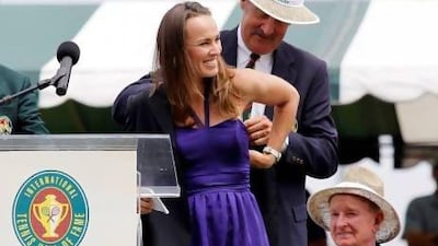 Don't be fooled by the awkward way Martina Hingis, left, had her Tennis Hall of Fame jacket is slipped on to her by fellow Hall of Famer Stan Smith, right. The Swiss was all grace and guile during her best years on the courts.