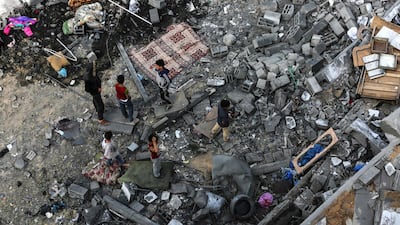 Palestinians children gather among the rubble. AFP