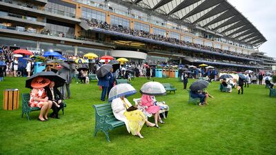 Racegoers shelter under umbrellas as they watch the racing on Day 1 of Royal Ascot. EPA