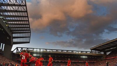 Liverpool players celebrate after Roberto Firmino scores their fourth goal against Leicester City. Paul Ellis / AFP