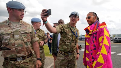 Hamilton poses for pictures as he arrives at Silverstone. AP