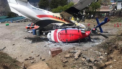 A Summit Air Let L-410 Turbolet aircraft bound for Kathmandu is seen after it hit two helicopters during take off at Lukla airport, the main gateway to the Everest region. A small plane veered off the runway and hit two helicopters while taking off near Mount Everest on April 14, killing three people and injuring three, officials said. / AFP / STR