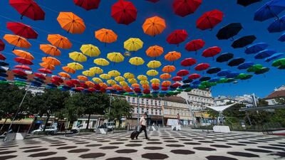 A man walks under spectral coloured umbrellas of the art installation ‘REGEN.WALD’ (rain.forest) in Vienna, Austria. The installation is part of the annual cultural projects ‘space and place’ and ‘Vienna lives’. Christian Bruna / EPA