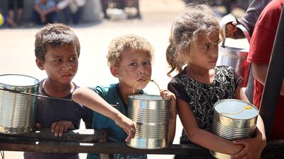 Children wait for food at a camp for internally displaced people in Khan Younis. AFP