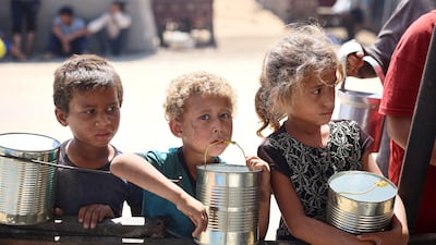 Children wait for food at a camp for displaced people at Khan Yunis, southern Gaza. AFP