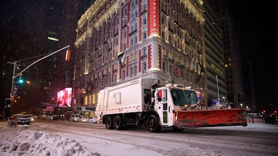 A snowplow drives through Times Square following road closures in New York City. Alex Trautwig / Getty Images / AFP