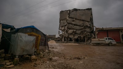 A family's tent pitched near a precarious ruined building in Jindires. An estimated 1.5 million people were left homeless in Syria and Turkey