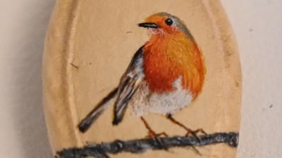 A bird painted on a pumpkin seed