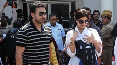 Shilpa Shetty, right, with her baby and husband, Raj Kundra; they own a flat in the Burj Khalifa. AFP