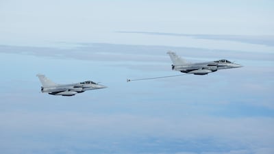 French Air Force Dassault Rafale B aircrafts escort an Airbus A330 MRTT (Multi Role Tanker Transport) refueling aircraft transporting France's President during a flight display, moments before its' landing at the Nuclear Submarine Navy Base of Ile Longue in Crozon, north-western France on March 2, 2026. High expectations, few certainties: on March 2, 2026, Emmanuel Macron is set to outline how France's nuclear deterrent can help strengthen security in Europe in the face of a increasingly brutal world and an increasingly uncertain US ally. This issue has been brought sharply into focus by the Israeli-US offensive in Iran this weekend, against the backdrop of the Iranian nuclear crisis, which is shaking the entire Middle East and, by extension, the international community. (Photo by Yoan VALAT / POOL / AFP)