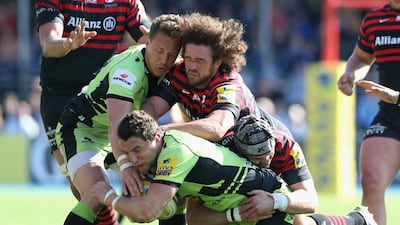Phil Dowson of Northampton is tackled by Jacques Burger and Eoin Sheriff, right, during the Aviva Premiership match between Saracens and Northampton Saints at Allianz Park on April 13, 2014 in Barnet, England. David Rogers/Getty Images