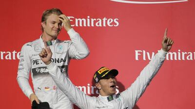 Mercedes driver Lewis Hamilton, front, celebrates after winning the Formula One US Grand Prix auto race at the Circuit of the Americas, as teammate Nico Rosberg, of Germany, who finished second, joins him on stage on Sunday, in Austin, Texas. Eric Gay / AP Photo