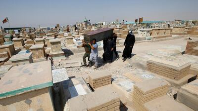 Iraqi men rebury a relative who was laid to rest in a cemetery dedicated to those who died of Covid-19 at the 'Valley of Peace' cemetery, in the city of Najaf, Iraq. Reuters