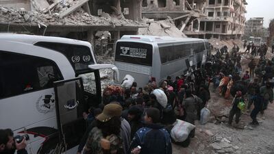 Syrians gather to board buses as they prepare to evacuate one of the few remaining rebel-held pockets in Arbin, in Eastern Ghouta, on the outskirts of the Syrian capital Damascus. Abdulmonam Eassa / AFP
