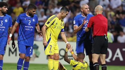 Al Nassr captain Cristiano Ronaldo helps up teammate Angelo Gabriel.