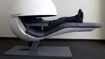 Metronaps CEO Arshad Chowdhury demostrates a prototype sleeping "pod" with a retractable shield that covers the upper body. Photo: Stan Honda / AFP