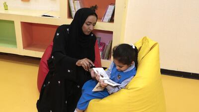 Teacher Najat Darwish Ali helps eight-year-old Nadha Al Naqbi, who is autistic, with her reading at Fujairah Rehabilitation Centre. Jeffrey E Biteng / The National