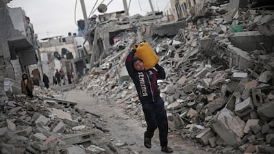 A Palestinian boy carries a water container amid the rubble of houses destroyed by Israeli bombardment in Rafah in the southern Gaza Strip. AFP