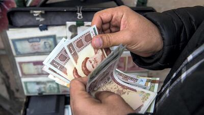 A currency trader counts rial banknotes in Iran. The currency's value against the dollar has plummeted as a result of more stringent US sanctions. Bloomberg