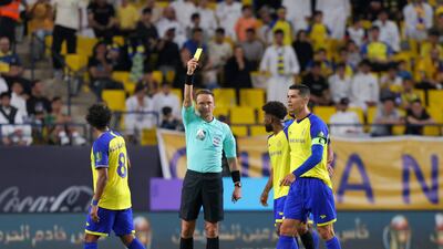Latvian match referee Andris Treimanis shows a yellow card. AFP