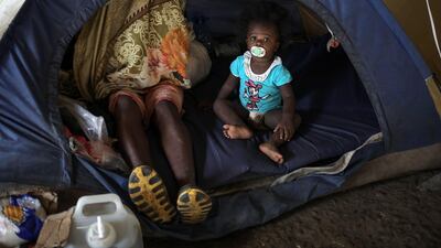 A toddler is seen with her mother in a tent at a camp in La Penita, Darien province, Panama, where hundreds of migrants remain amid the Covid-19 coronavirus pandemic. AFP