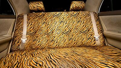 An abstract tiger print seat cover in the back of an Abu Dhabi taxi cab.