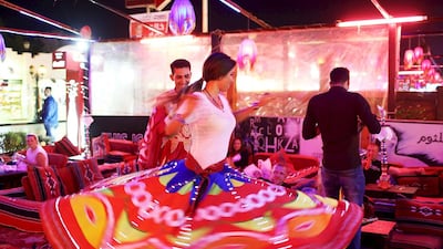 A dancer lets a tourist practice the traditional tannoura dance at a cafe in the Red Sea resort of Sharm El Sheikh. Asmaa Waguih / Reuters
