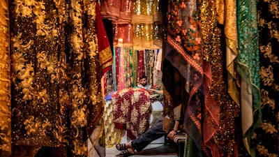A shopkeeper and a friend inside his textile shop at the main market of the Kurdish-majority city of Qamishli in Syria's northeastern Hasakeh province on May 19, ahead of the upcoming Muslim holiday of Eid Al Fitr celebrated at the conclusion of the holy fasting month of Ramadan. Delil Souleiman / AFP