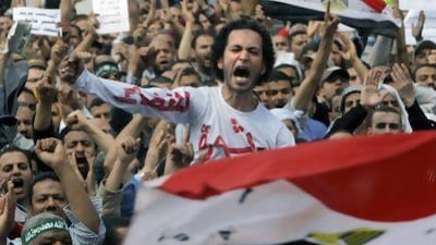 Egyptian Muslim Brotherhood members, one wearing a t-shirt that reads “clean judiciary” protest in front of the Supreme Judicial Council in Cairo.