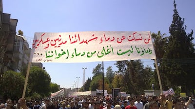 Syrian anti-government protesters in May 2011 carry a banner that reads in Arabic: ”Our blood is not more precious than the blood of our brothers, the youth of Homs” during a rally in the central city of Homs. AP Photo