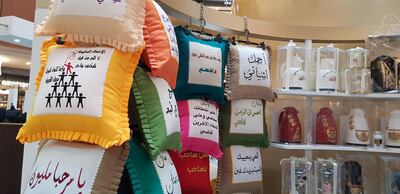 Cushions emblazoned with Arabic script sit alongside handpainted coffee pots. Selina Denman / The National